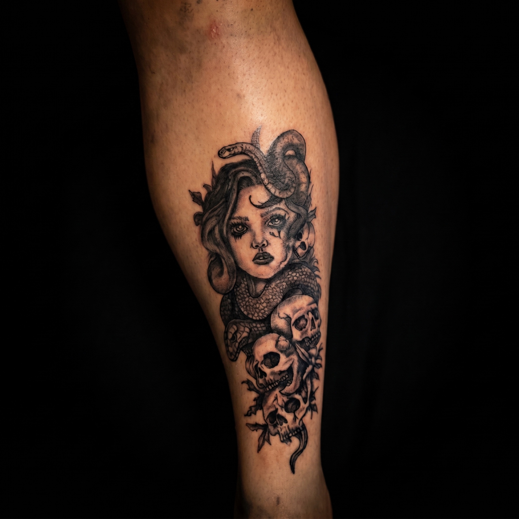 Black and grey Medusa portrait with snakes on a calf